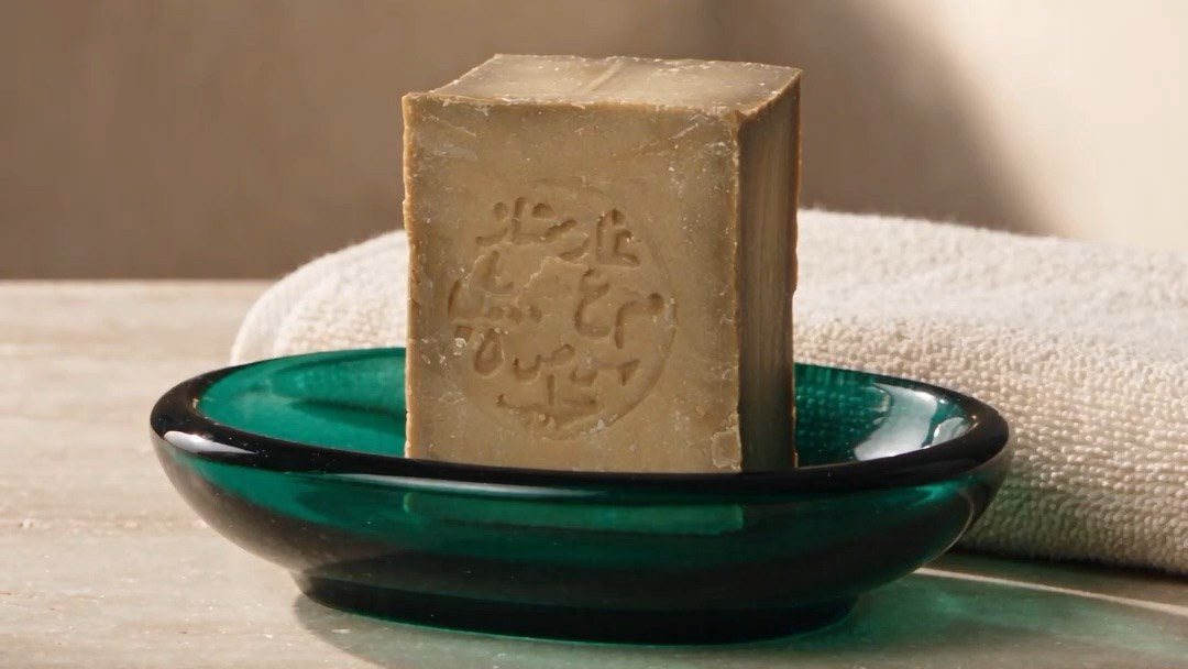 A bar of Aleppo soap drying on a draining soap dish